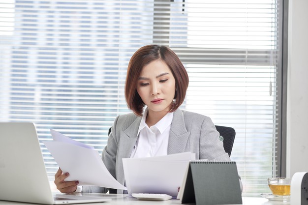 happy-asian-woman-working-office-female-going-through-some-paperwork-work-place_264197-2174
